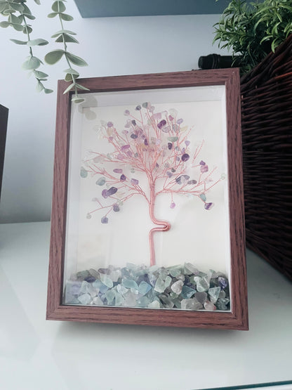 A framed natural crystal tree art piece with mix crystal in a brown wooden frame